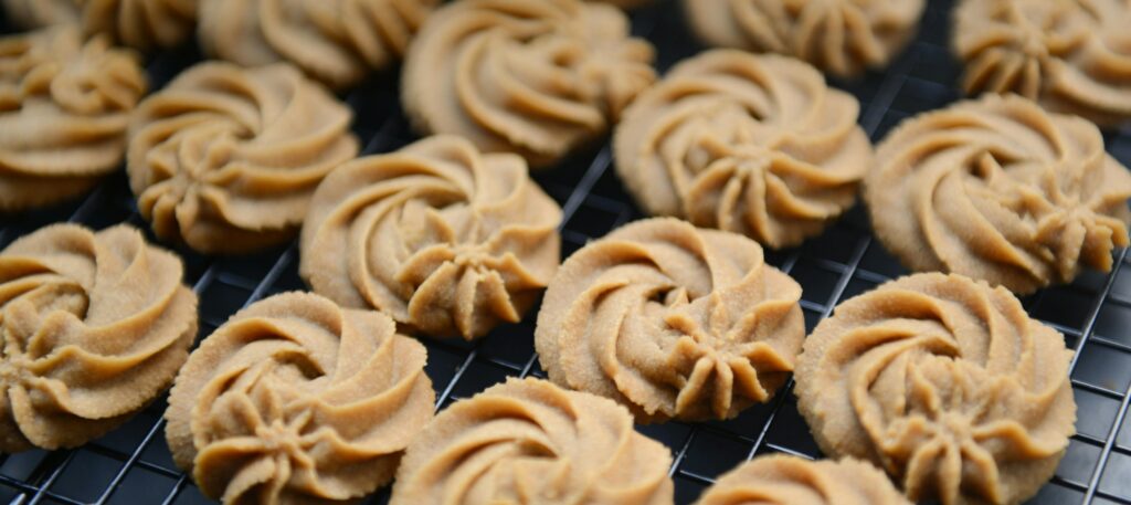 Freshly baked butter cookies arranged on a cooling rack, showcasing their intricate swirls.